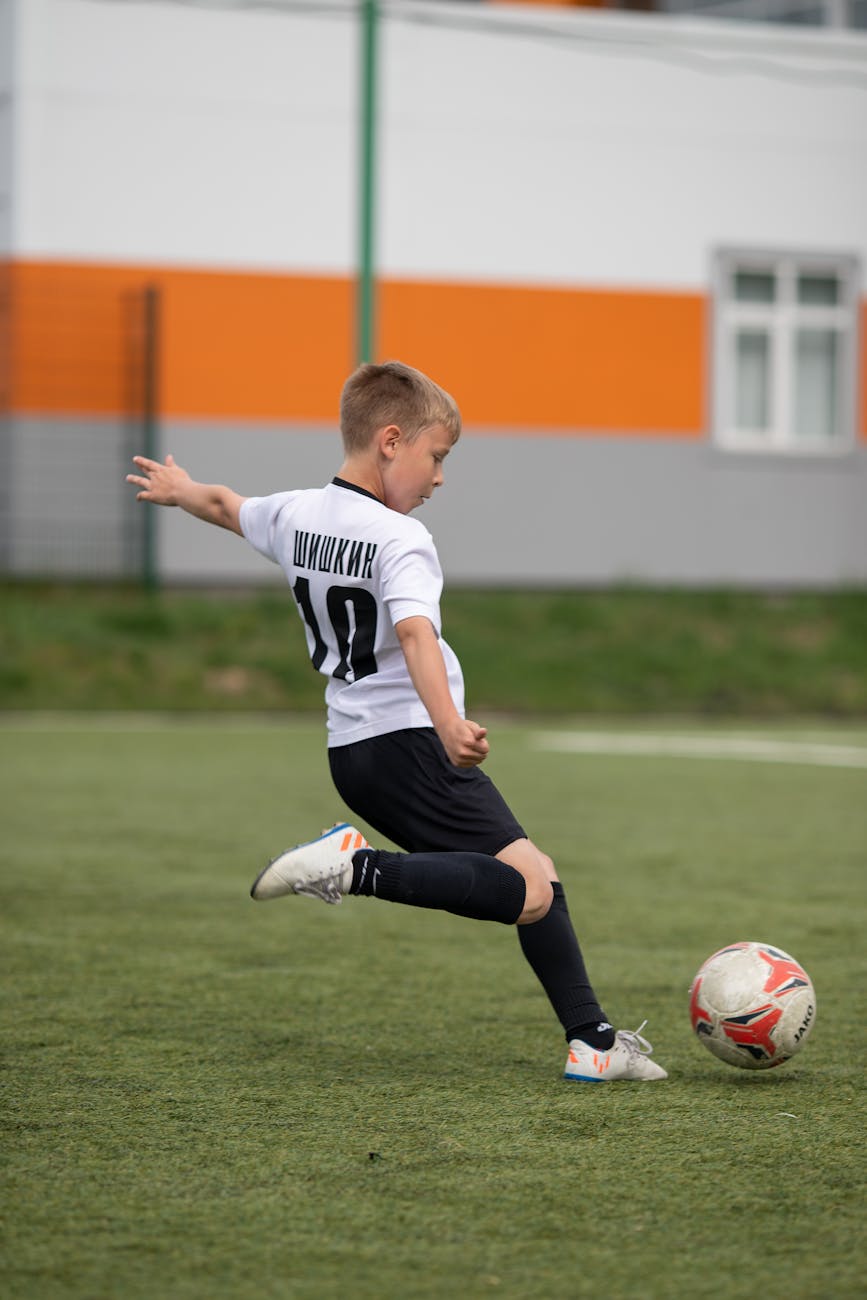 boy in white jersey playing soccer