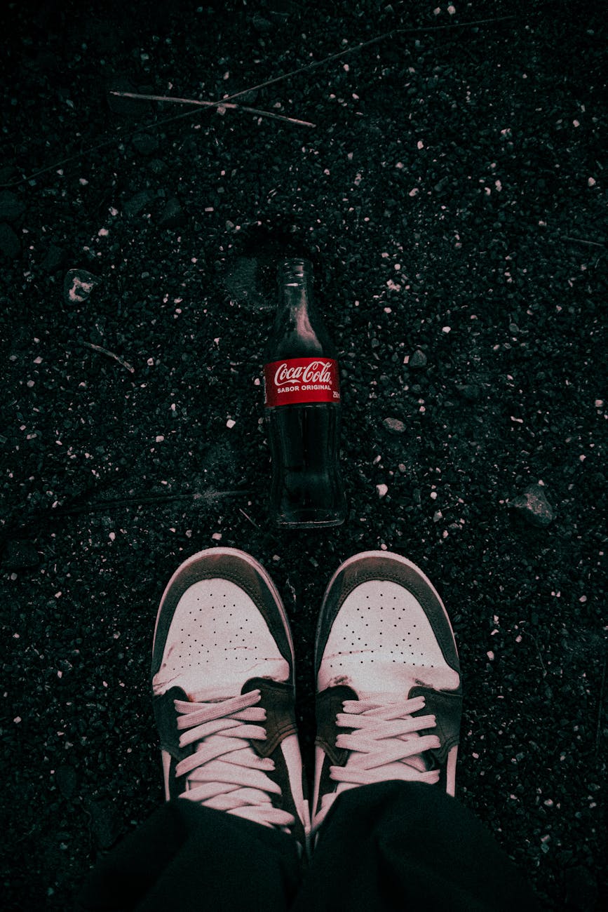 vintage sneakers and empty bottle on ground