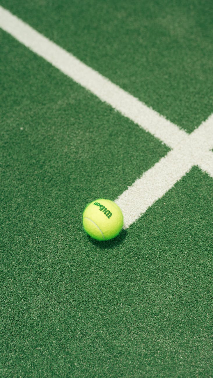 tennis ball on green court surface