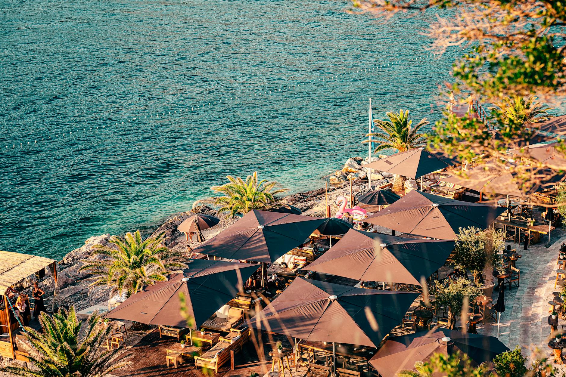 big brown umbrellas near the sea with turquoise water