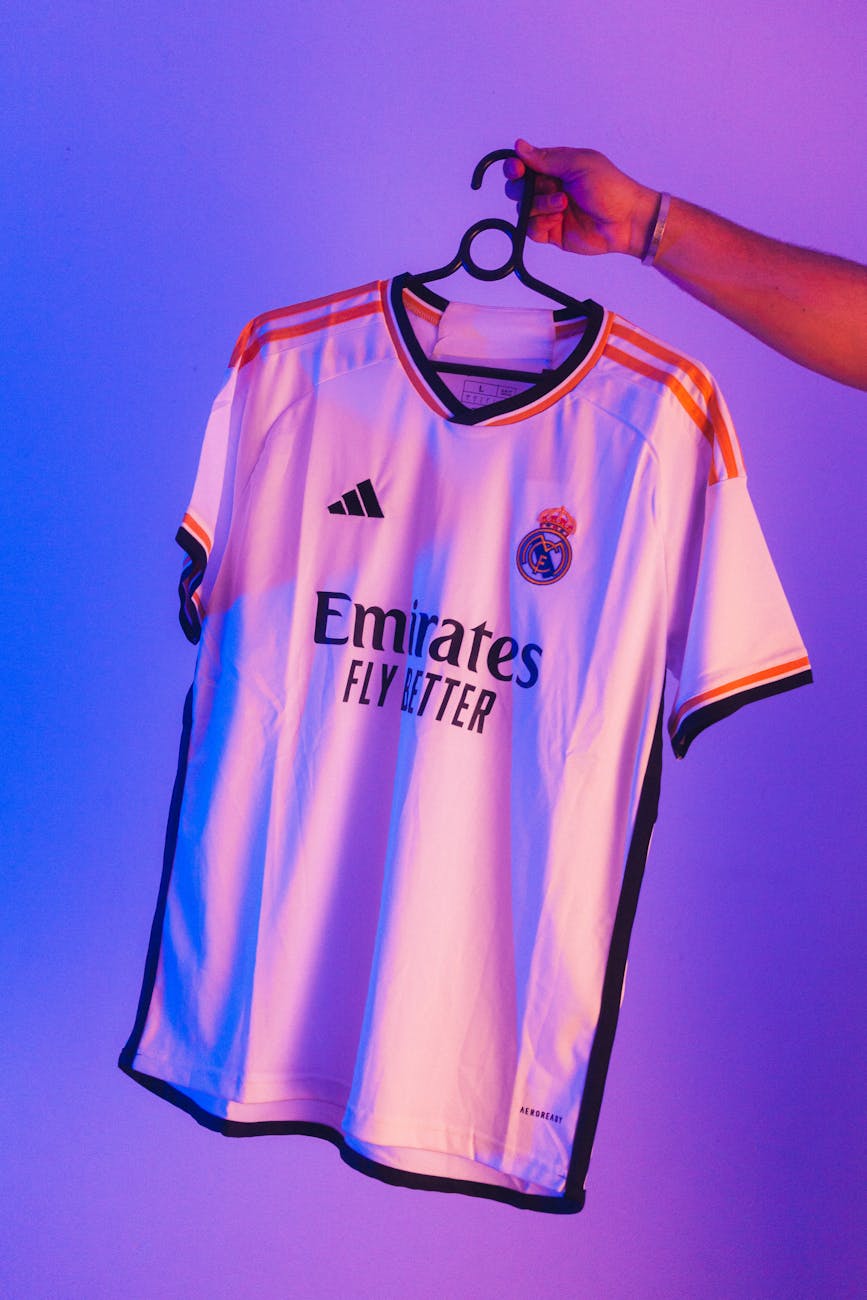 man holding a sports t shirt on a clothes hanger